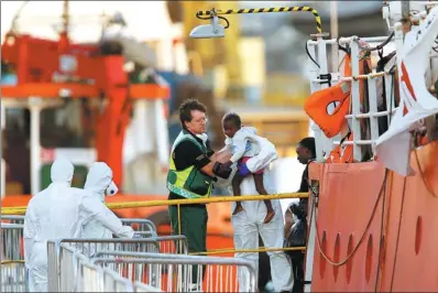  ?? DARRIN ZAMMIT LUPI / REUTERS ?? A migrant child is carried from the charity ship at Boiler Wharf in Senglea, in Valletta’s Grand Harbour, Malta, on Wednesday.