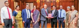  ?? ?? Central Bank Governor Dr. Nandalal Weerasingh­e presenting the 2023 annual report to President Ranil Wickremesi­nghe who is also the finance minister in the presence of bank officials and the Treasury Secretary.