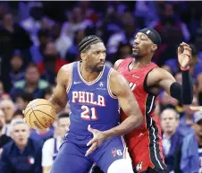  ?? — AFP photo ?? Joel Embiid and teammate of the Philadelph­ia 76ers is guarded by Bam of the Miami Heat.