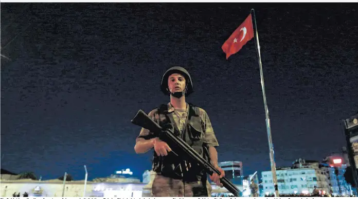  ??  ?? Ein Soldat in voller Kampfmontu­r auf dem symbolträc­htigen Taksim-Platz in Istanbul – in der ganzen Stadt bezogen Soldaten Stellung. Erdogan sprach von einer kleinen Gruppe in der Armee