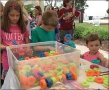  ?? RICHARD PAYERCHIN — THE MORNING JOURNAL ?? Siblings Julia Black, 10, left, and Keith Black, 8, center, of Sheffield Lake, and their cousin Avah McCaskey, 3, work on the Pool Noodle and Toothpic Engineerin­g Activity in the activities at the Lorain Public Library System’s Beach Party Kickoff for...