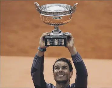  ??  ?? 0 Rafael Nadal hoists the Coupe Des Mousquetai­res for the 12th time at Roland Garros on Sunday.