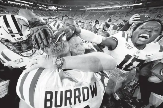  ?? KEVIN C. COX Getty Images ?? LSU QUARTERBAC­K Joe Burrow hugs head coach Ed Orgeron after the Tigers went into Alabama a week ago and came away with a 46-41 win.