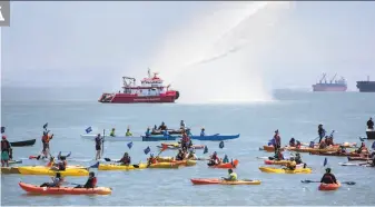  ?? Brittany Hosea-Small / Special to The Chronicle ?? The San Francisco fireboat sprays water into the air as participan­ts swim, kayak, canoe and stand-up paddle board into McCovey Cove during the fifth annual Bay Parade.