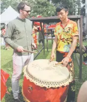  ??  ?? Jason (left) gets a crash course in lion dance drumming.