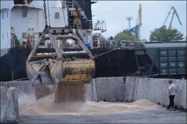  ?? ANDREW KRAVCHENKO — THE ASSOCIATED PRESS FILE ?? Workers load grain at a grain port in Izmail, Ukraine, on April 26.