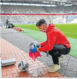  ?? SASCHA SCHUERMANN / EFE ?? Un empleado desinfecta el balón durante el Fortuna Dusseldorf-Paderborn.