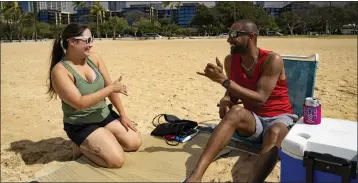  ?? MENGSHIN LIN — THE ASSOCIATED PRESS ?? Mignon Walter, left, of Honolulu exchanges a shaka with Marcus Grayson, of Las Vegas at Ala Moana Beach on March 6 in Honolulu, Hawaii.