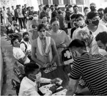  ?? PHOTO: PTI ?? Beneficiar­ies wait to receive Covid-19 vaccine dose at SKM hall, in Patna, on Thursday