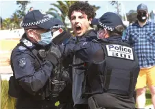  ?? — AFP photo ?? Police arrest a protester at St Kilda in Melbourne, during an anti-lockdown rally.