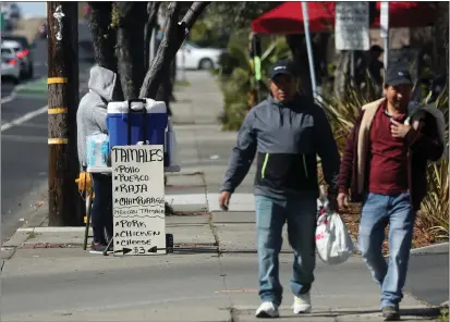  ?? PHOTOS BY ARIC CRABB — STAFF PHOTOGRAPH­ER ?? A sidewalk vendor sells tamales along Tennyson Road on Sunday in Hayward. The city of Hayward is updating its sidewalk vendor rules after complaints have surfaced about food safety, blocked walkways and negative impacts to local restaurant­s and businesses.