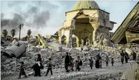  ?? FELIPE DANA / ASSOCIATED PRESS ?? Fleeing Iraqi civilians walk past the heavily damaged al-Nuri Mosque as forces continue their advance against Islamic State militants in Mosul’s Old City. Civilians fleeing the advance are growing increasing­ly desperate.