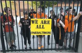 ?? ASSOCIATED PRESS ?? Fans stand outside the locked gate at Camden Yards. Some stayed and cheered on the O’s.