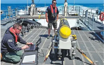  ?? AP ?? US Navy sailors prepare a CARINA unmanned undersea drone off San Diego. The drones will protect a region of chokepoint­s crucial to both global energy supplies and worldwide shipping.