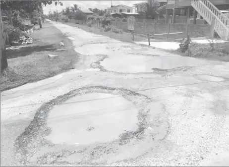  ??  ?? Large potholes filled with water occupy the entire width of one of the roads in Industry