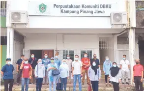  ??  ?? LAWATAN: Ahli rombongan lawatan merakam kenangan di hadapAn Perpustaka­an Komuniti DBKU Kampung Pinang Jawa.