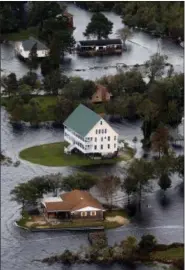  ?? STEVE HELBER — THE ASSOCIATED PRESS ?? Houses are surrounded by water from Florence, now a tropical storm, in New Bern, NC., Saturday.