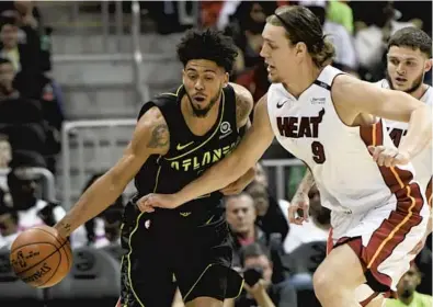  ?? JOHN AMIS/AP ?? Miami’s Kelly Olynyk puts pressure on Atlanta Hawks guard Tyler Dorsey during the first half of Wednesday night’s game in The Heat completed a back-to-back sweep of the Hawks with the easy 29-point victory. Atlanta.