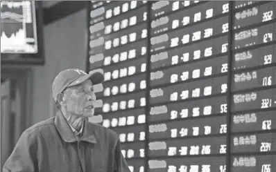  ?? SU YANG / FOR CHINA DAILY ?? A pensioner, tension writ large on his face, checks stock prices at a brokerage in Nanjing, Jiangsu province, on Dec 12, when Chinese stocks fell the most in six months.