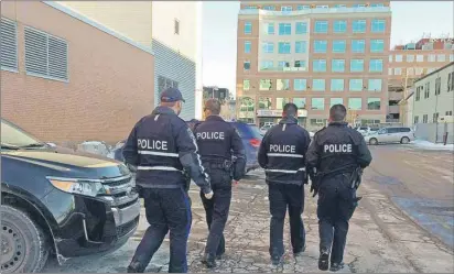  ?? NIGEL ARMSTRONG/THE GUARDIAN ?? Police officers from Charlottet­own Police Services meet in the back parking lot of the Jean Canfield federal building in Charlottet­own Wednesday after visually sweeping the exterior. A bomb threat against the building came in around 3:30 p.m., the...