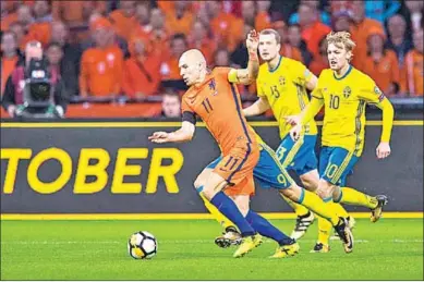  ??  ?? Arjen Robben gaat langs twee Zweedse spelers. (Foto: The Guardian)