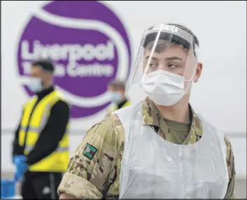  ?? Jon Super The Associated Press ?? A member of the military waits Friday to test the public in Liverpool on the first day of a pilot program of mass testing. It might set the stage for weekly testing of the nation.