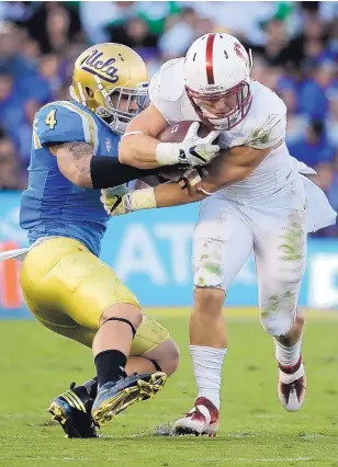  ?? CHRIS CARLSON/ASSOCIATED PRESS ?? Stanford running back Christian McCaffrey, right, breaks away from UCLA linebacker Cameron Judge during the first half of their game Saturday night in Pasadena, Calif.