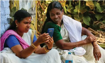  ?? Photograph: NurPhoto/Getty Images ?? Women look at a mobile phone during the Hindu Attukal Pongala festival in Kerala, India.