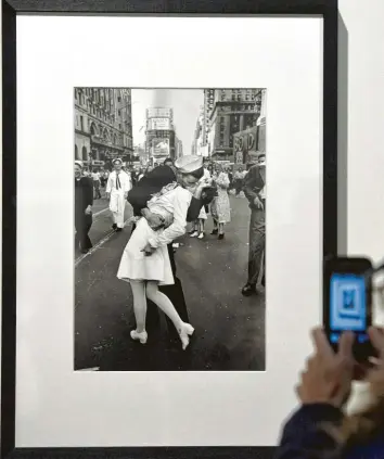  ?? Foto: Gabriel Bouys, afp ?? Dieses Bild ging um die Welt: George Mendonsa küsst am 14. August 1945 die Zahnarztas­sistentin Greta Friedman. Verheirate­t war er allerdings mit Rita Petrie, die auf dem Bild ebenfalls zu sehen ist – die lachende Frau (nur schwer erkennbar) direkt über dem Oberarm des Matrosen der Us-navy.