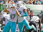  ?? CHARLES TRAINOR JR. / MIAMI HERALD ?? Kiko Alonso (47) and T.J. McDonald celebrate a secondquar­ter fumble recovery against the Jets on Sunday at MetLife Stadium in N.J.