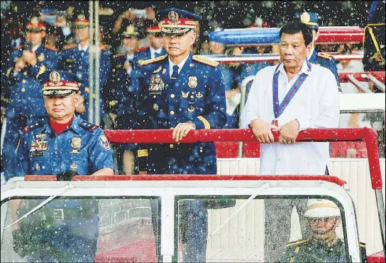  ?? KRIZJOHN ROSALES ?? President Duterte and PNP chief Director General Oscar Albayalde troop the line during the 117th Police Service anniversar­y celebratio­n at Camp Crame yesterday.