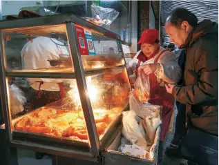  ??  ?? A resident chooses his breakfast at the snack bar of the wet market.