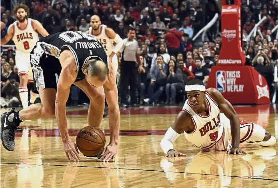  ?? — AP ?? Mad scramble: San Antonio Spurs guard Manu Ginobili ( left) and Chicago Bulls guard Rajon Rondo go for a loose ball during the first quarter of their NBA game in Chicago on Thursday.