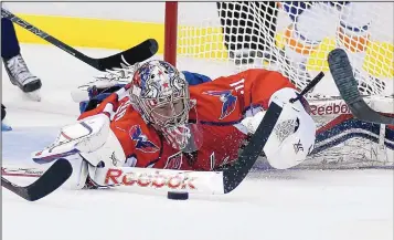  ?? ALEX BRANDON/JOURNAL Washington fill-in goalie Philipp Grubauer lunges to knock the puck away during the second period of the Capitals’ Game 2 win over the Islanders on Friday night. ??