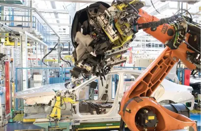  ?? — AFP ?? A robot mounts a cockpit into a Mercedes-Benz S-Class car at a plant of the luxury carmaker in Sindelfing­en, Germany.