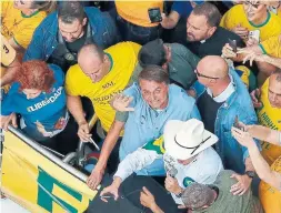  ?? MIGUEL SCHINCARIO­L AFP VIA GETTY IMAGES ?? Brazilian President Jair Bolsonaro waves as he joins thousands of fans marching Sunday in Brazil. Bolsonaro has been locked in a feud with the Supreme Court, in particular a justice who has jailed several of the president’s supporters.