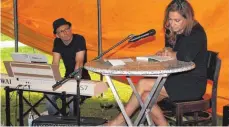  ??  ?? Autorin Valerie Gerards wird bei ihrer Lesung im Zelt an der Donau musikalisc­h von Uwe Schönwiese unterstütz­t.