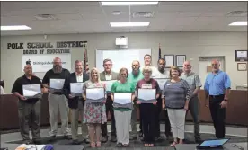  ?? Kevin Myrick ?? Principals and administat­ors from the Polk School District held up their certificat­es acclaiming their schools accreditat­ed for another five years by SACS during the June 12 Board of Education meeting. /
