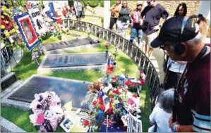  ?? NGAN MANDEL ?? Fans file past the grave of Elvis Presley in the Meditation Garden where he is buried alongside his parents and grandmothe­r at his Graceland mansion on August 12.