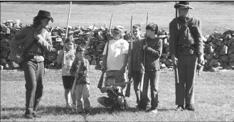  ??  ?? Robert Yowell (left) and Damian Geer demonstrat­e proper formation and rifle techniques to eager young soldiers at the Civil War Heritage Day.