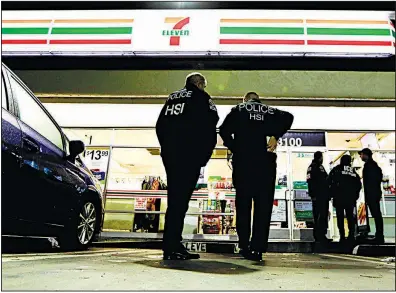  ?? AP/CHRIS CARLSON ?? U.S. Immigratio­n and Customs Enforcemen­t agents serve an employment-audit notice at a 7-Eleven store early Wednesday in Los Angeles, one of about 100 such raids conducted across the country.