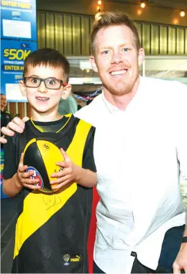  ??  ?? Above: It’s a Tiger stands with his trainer before moving to his box in preparatio­n for race four on Saturday night.
Left: Young Josh Robertson of Lardner won a competitio­n to have a kick and a chat with Richmond star Jack Riewoldt on the night.