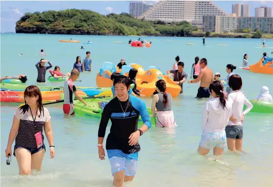  ?? PHOTO AFP ?? Malgré la menace proférée par la Corée du Nord plus tôt cette semaine, des touristes profitaien­t des plages sur l’île de Guam hier.