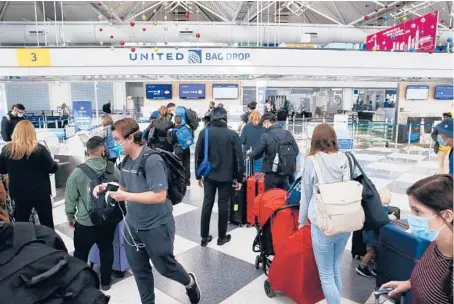  ?? STACEY WESCOTT/CHICAGO TRIBUNE ?? Travelers on United Airlines make their way through a terminal at Chicago O’Hare Internatio­nal Airport on Nov. 20, 2020.