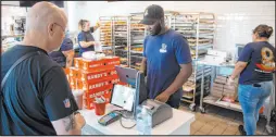  ?? Steel Brooks
Las Vegas Review-journal ?? Daniel Ramadji serves customers at Randy’s Donuts. After debuting last month to daily doughnut sellouts, the shop on South Rainbow Boulevard has finally launched 24/7 service.