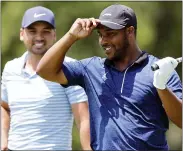  ?? ASSOCIATED PRESS FILE PHOTO ?? Harold Varner III, right, prepares to hit his tee shot during an exhibition event before last year’s Rocket Mortgage Classic. He later tied for 30th in the RMC. The PGA Tour event is staging a four-day event this year to create more playing and business opportunit­ies in golf for Blacks.