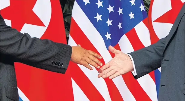  ?? AP ?? US President Donald Trump, right, reaches to shake hands with North Korea leader Kim Jong-Un at the Capella resort on Sentosa Island in Singapore on Tuesday.