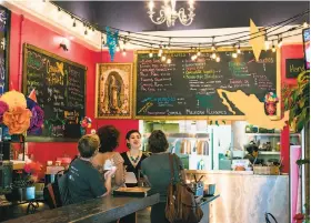  ?? Photos by Jen Fedrizzi / Special to The Chronicle ?? Julia Barrios explains the menu at the colorful Tacorgasmi­co in S.F. The restaurant, in the Castro neighborho­od, offers fresh, homemade flour tortillas.