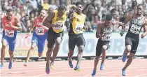  ?? RICARDO MAKYN/MULTIMEDIA PHOTO EDITOR ?? Usain Bolt, on anchor, receives the baton from Michael Campbell during the sprint relay heats at the IAAF World Championsh­ips in London, England, on Saturday.