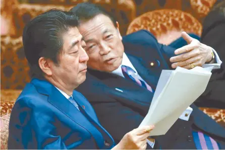  ?? EPA-Yonhap ?? Japanese Prime Minister Shinzo Abe, left, talks with Finance Minister Taro Aso prior to the opening of the Upper House budget committee in Tokyo, Friday.